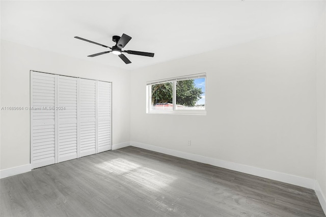 unfurnished bedroom with a closet, hardwood / wood-style flooring, and ceiling fan