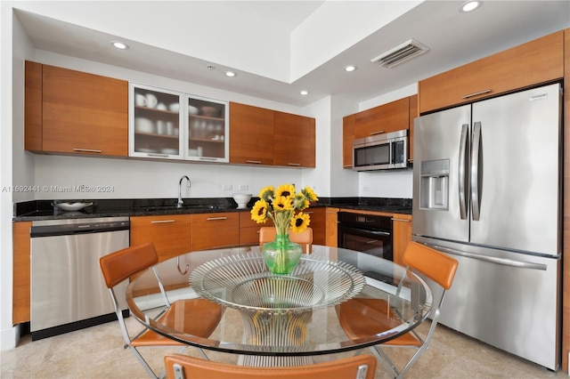 kitchen featuring dark stone counters, sink, and stainless steel appliances