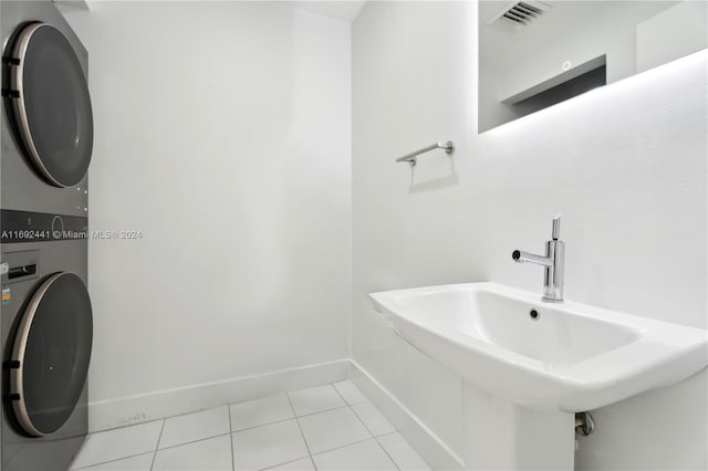 bathroom featuring stacked washer / dryer, tile patterned flooring, and sink