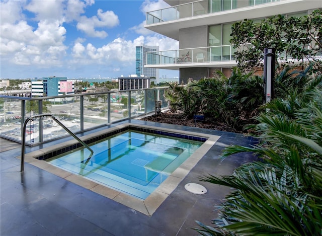 view of pool with a hot tub