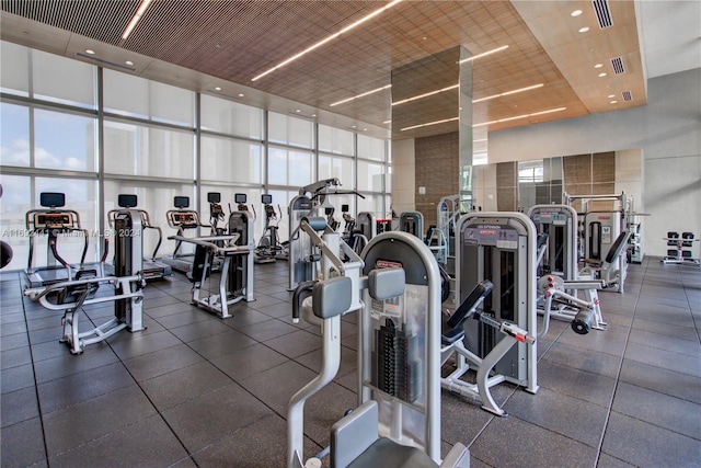 gym with a high ceiling and a wall of windows