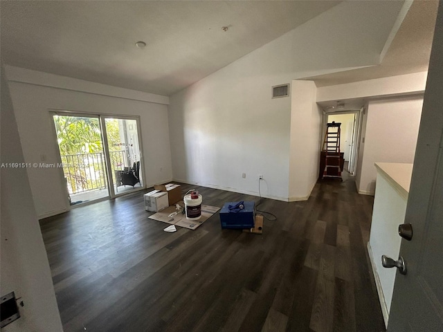 spare room with dark wood-type flooring and vaulted ceiling