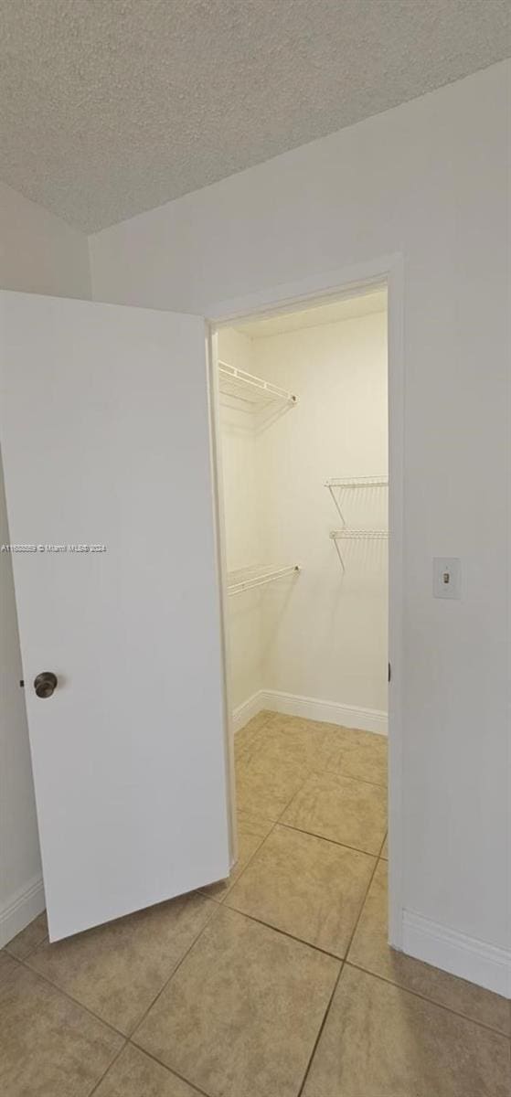 spacious closet featuring light tile patterned floors