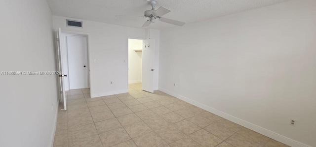 empty room with ceiling fan and a textured ceiling