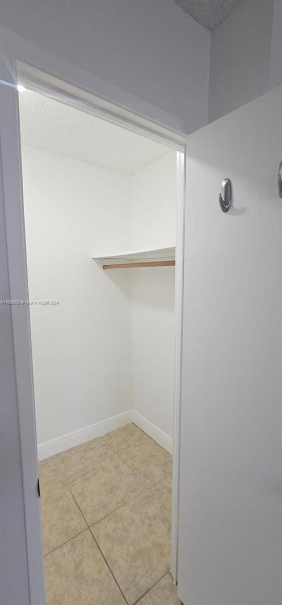 walk in closet featuring light tile patterned flooring