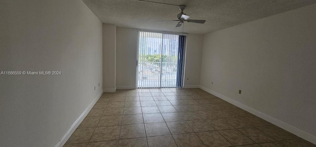 tiled empty room with ceiling fan and a textured ceiling