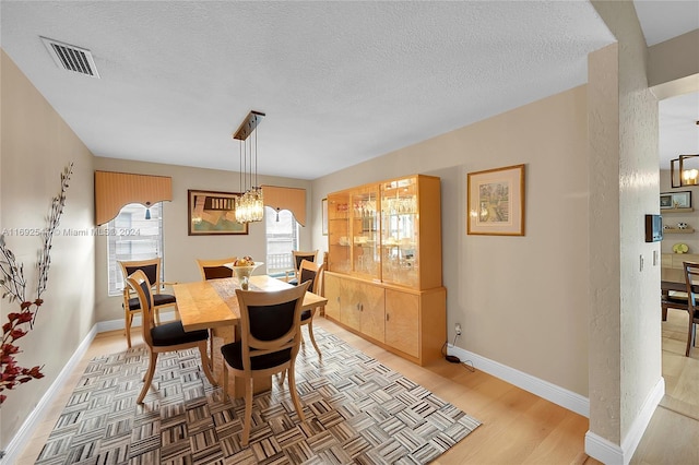 dining room with a textured ceiling and a chandelier