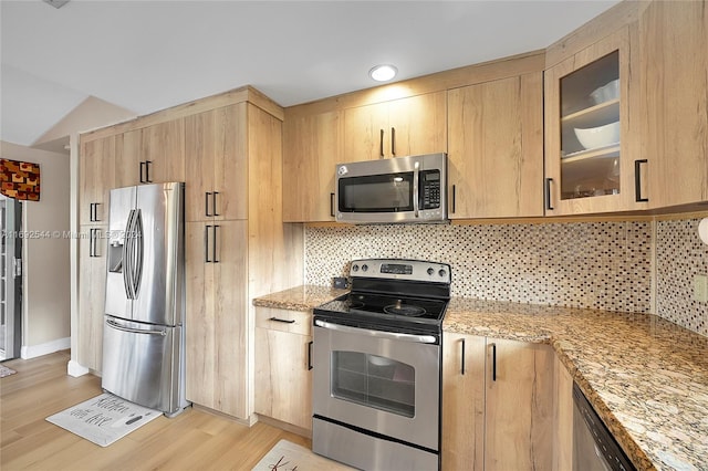 kitchen featuring light stone countertops, light wood-type flooring, and appliances with stainless steel finishes