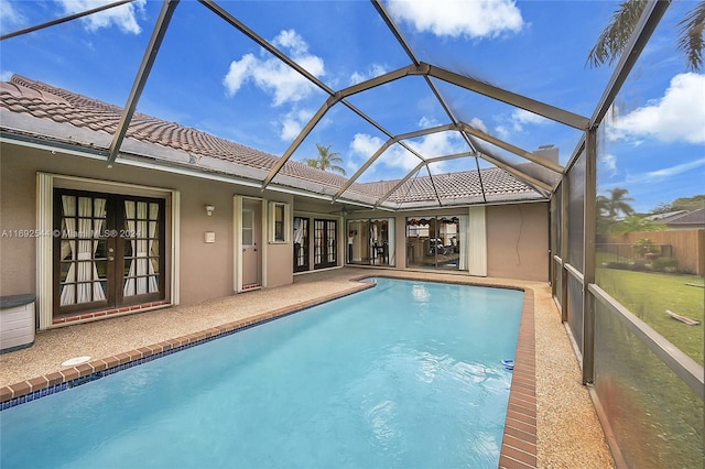 view of pool with glass enclosure, french doors, and a patio area