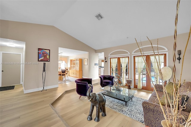 living room featuring hardwood / wood-style floors, french doors, and vaulted ceiling