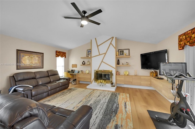 living room with ceiling fan, light wood-type flooring, and lofted ceiling