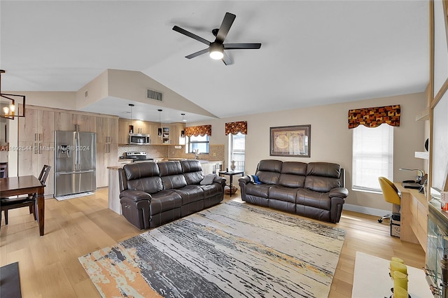 living room with ceiling fan with notable chandelier, light wood-type flooring, and lofted ceiling