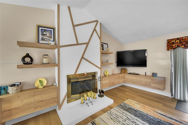 living room featuring light wood-type flooring and lofted ceiling