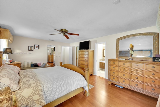 bedroom featuring hardwood / wood-style flooring, ceiling fan, and ensuite bath