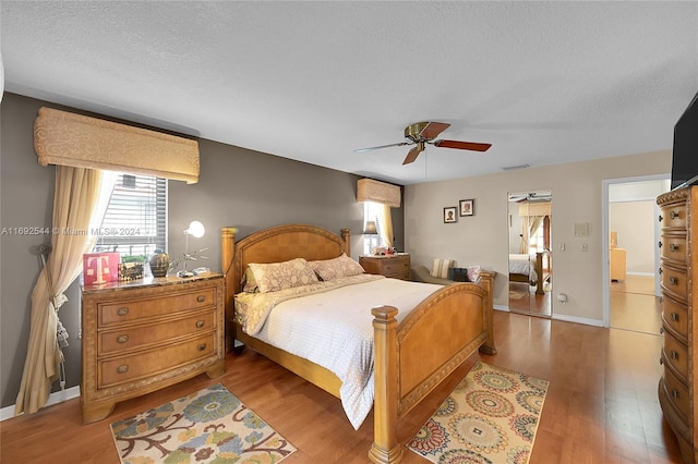 bedroom featuring a textured ceiling, light hardwood / wood-style floors, and ceiling fan