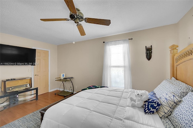 bedroom featuring a textured ceiling, hardwood / wood-style floors, and ceiling fan