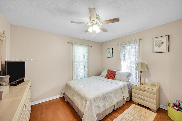 bedroom featuring a textured ceiling, hardwood / wood-style floors, and ceiling fan