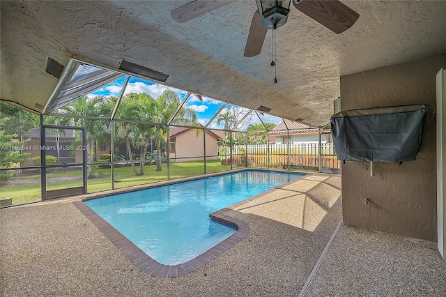 view of swimming pool with a patio, a lanai, and ceiling fan