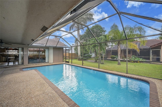 view of pool featuring glass enclosure, a yard, and a patio