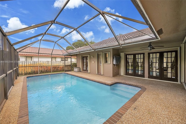 view of swimming pool featuring ceiling fan, a lanai, french doors, and a patio area