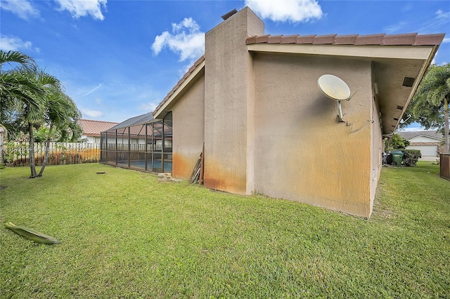 exterior space featuring a fenced in pool, glass enclosure, and a yard