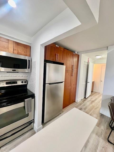 kitchen featuring stainless steel appliances and light hardwood / wood-style floors