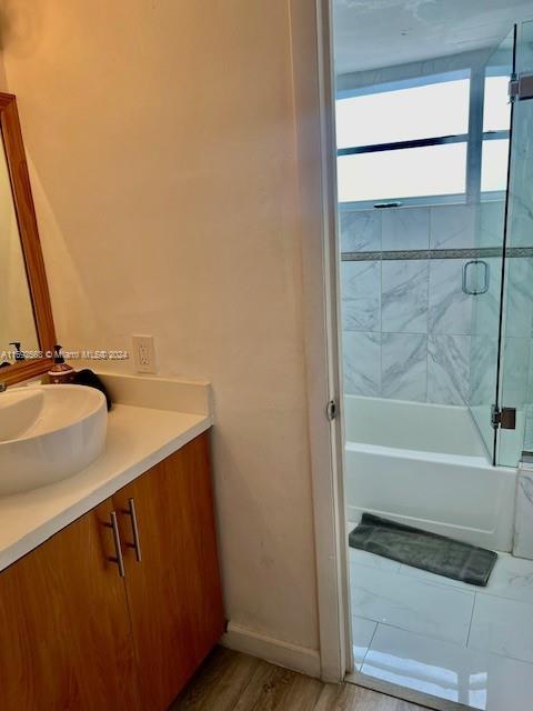 bathroom featuring hardwood / wood-style floors, vanity, and tiled shower / bath