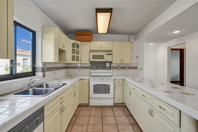 kitchen with tasteful backsplash, sink, tile countertops, and white appliances