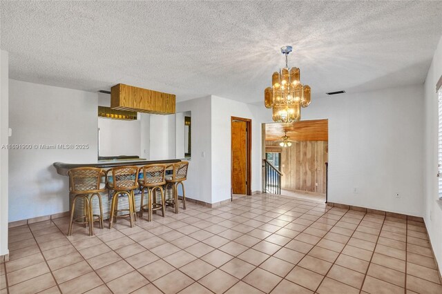 kitchen featuring hanging light fixtures, an inviting chandelier, light tile patterned floors, and a textured ceiling