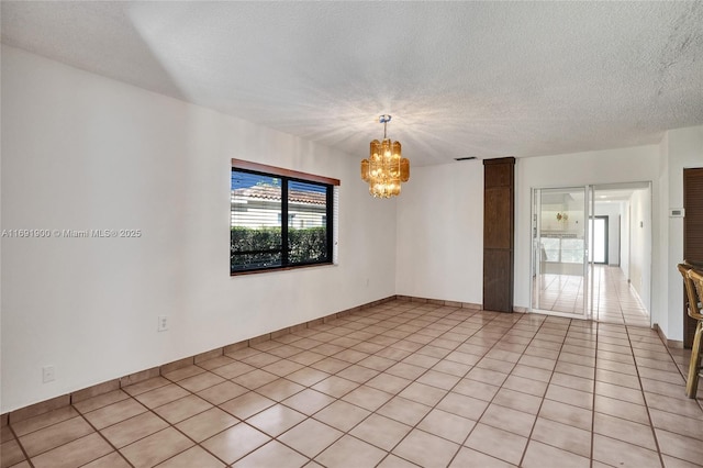 unfurnished room with light tile patterned floors, a notable chandelier, and a textured ceiling