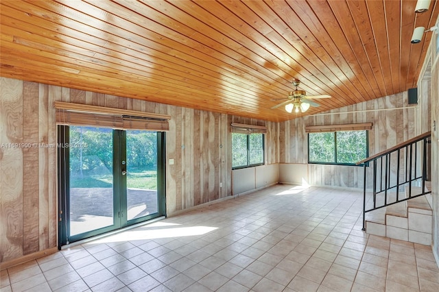 spare room with lofted ceiling, light tile patterned floors, wood ceiling, and wooden walls