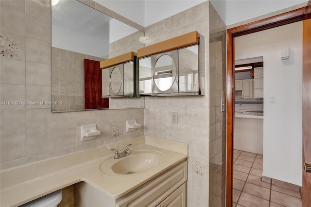 bathroom with tile patterned flooring, vanity, tile walls, and backsplash