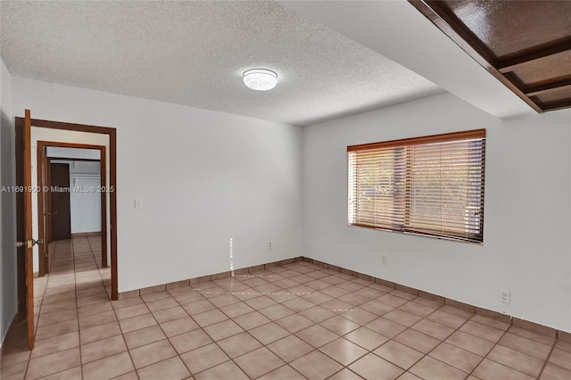 tiled spare room with a textured ceiling