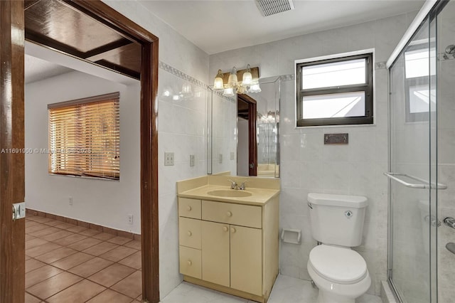 bathroom featuring vanity, toilet, an enclosed shower, and tile walls