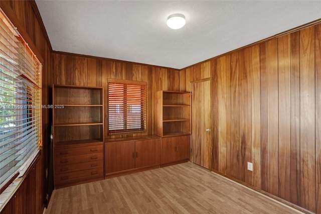 unfurnished room with wooden walls and light wood-type flooring