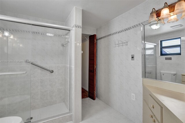 bathroom featuring vanity, a shower with door, and toilet