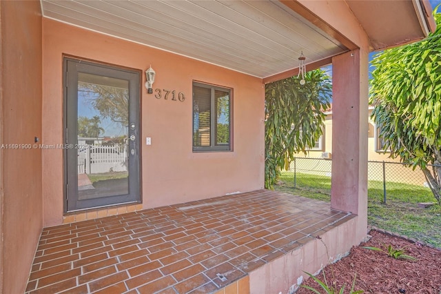 view of exterior entry with a patio