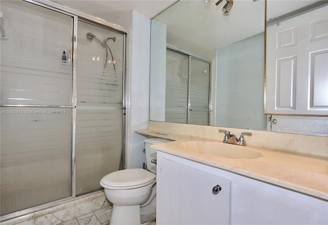 bathroom featuring a shower with door, vanity, and toilet