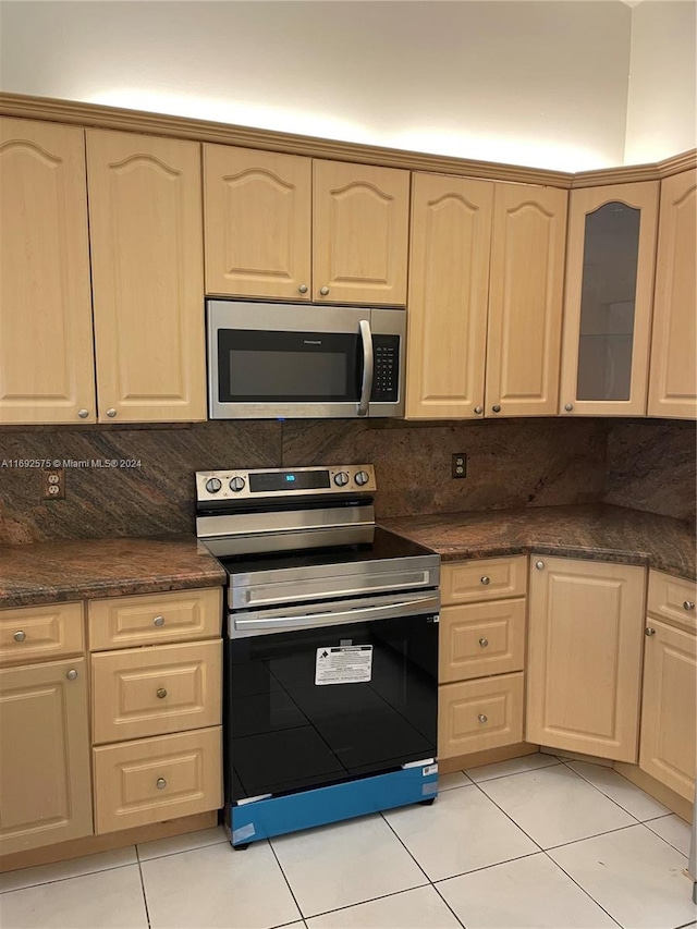 kitchen featuring tasteful backsplash, light brown cabinets, light tile patterned flooring, and appliances with stainless steel finishes