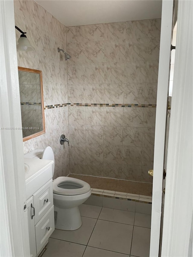 bathroom with vanity, tile patterned flooring, toilet, walk in shower, and tile walls