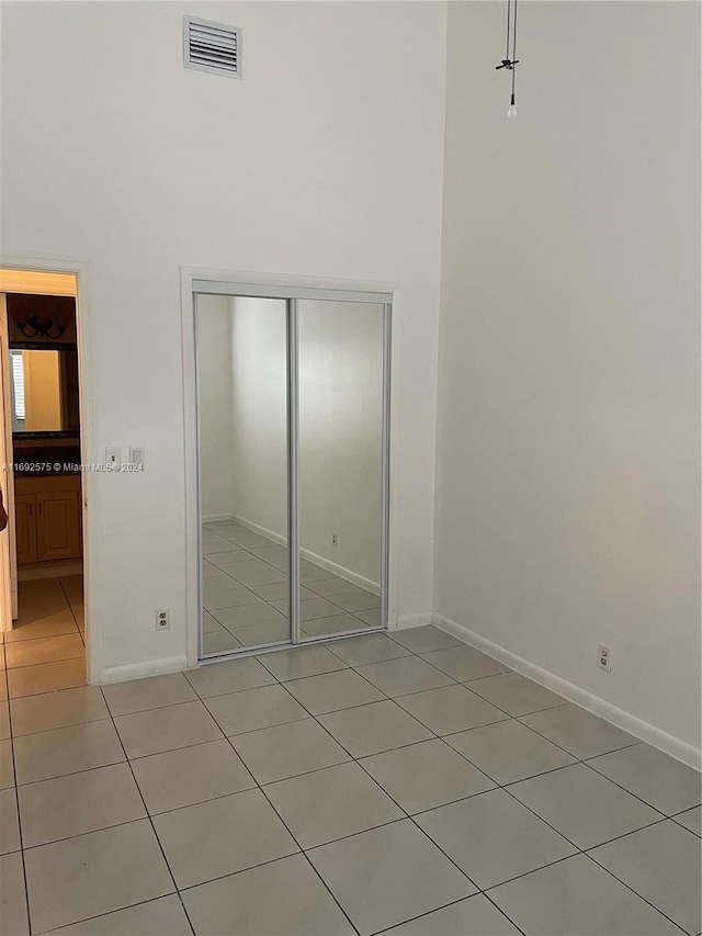 unfurnished bedroom with light tile patterned floors and a closet