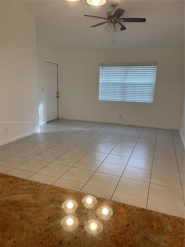 unfurnished room featuring ceiling fan and light tile patterned floors