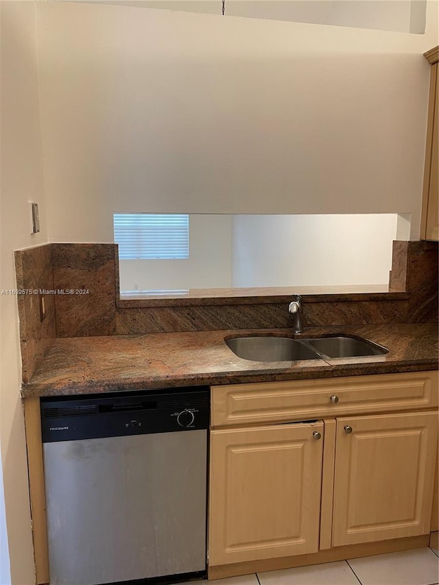 kitchen with light tile patterned floors, stainless steel dishwasher, and sink