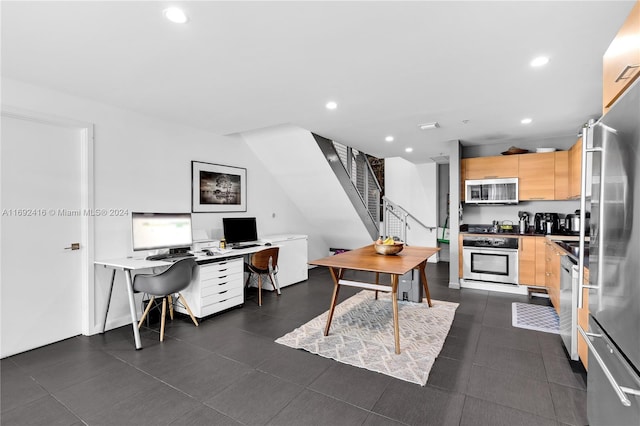 interior space with light brown cabinets, a kitchen breakfast bar, and stainless steel appliances