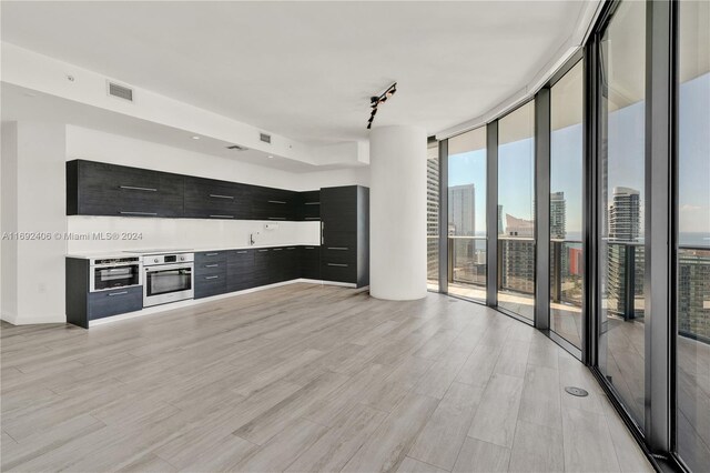 45 SW 9th St Unit 4306, Miami, FL 33130 - unfurnished living room featuring expansive windows, light wood-type flooring, and rail lighting