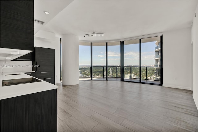 unfurnished living room featuring light hardwood / wood-style flooring and floor to ceiling windows