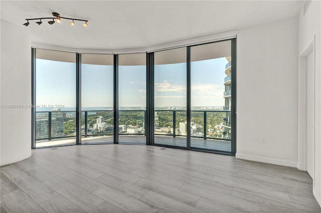 45 SW 9th St Unit 4306, Miami, FL 33130 - empty room with a wall of windows, healthy amount of natural light, wood finished floors, and rail lighting