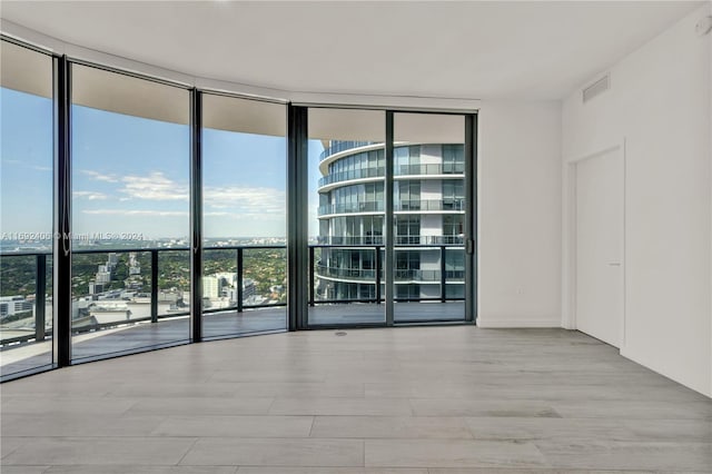 unfurnished room with a wall of windows