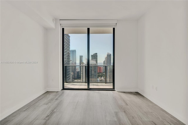45 SW 9th St Unit 4306, Miami, FL 33130 - unfurnished room featuring expansive windows, wood finished floors, a skyline view, and baseboards
