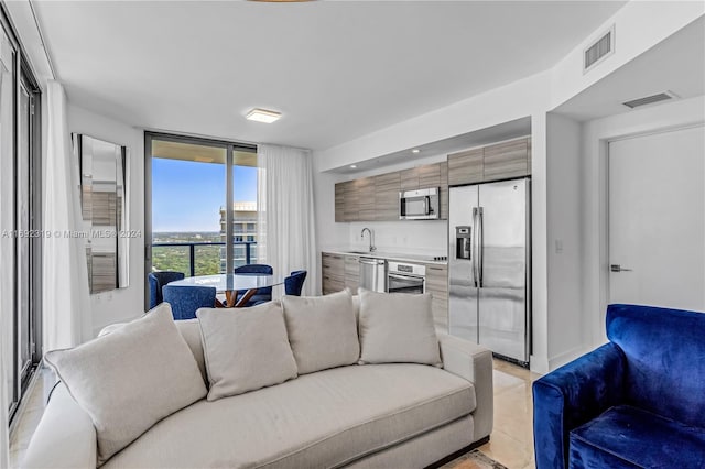 living room featuring sink and floor to ceiling windows